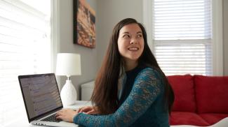 Student studying at home with laptop.